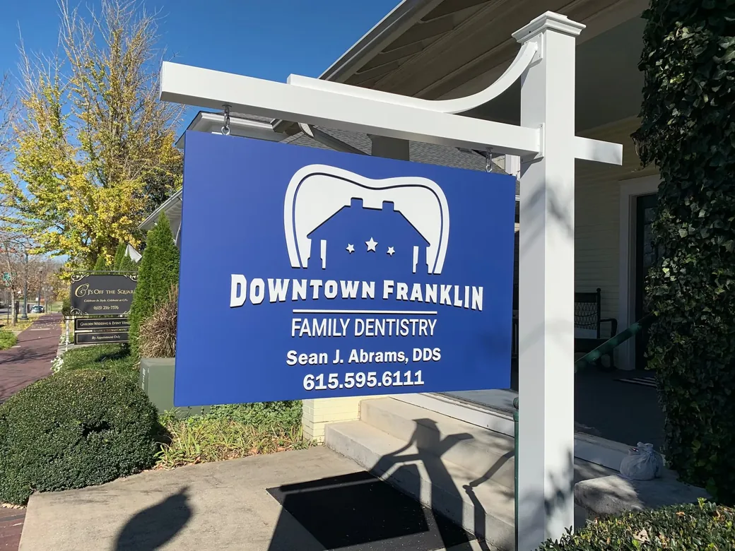 Blue Downtown Franklin Family Dentistry sign displayed between white posts