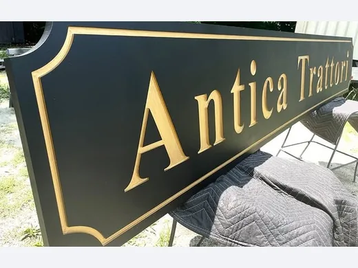 Antica Trattoria black and gold hanging restaurant sign with routed border