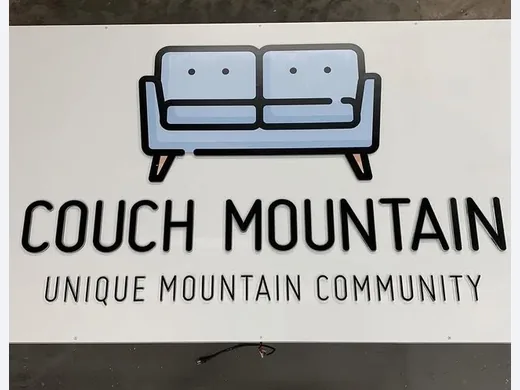Couch Mountain community sign with dimensional sofa logo and black lettering