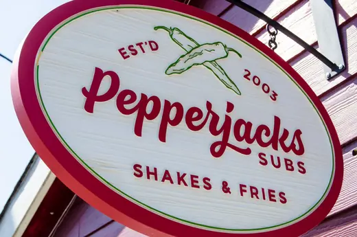 Pepperjacks shakes and fries round projecting sign