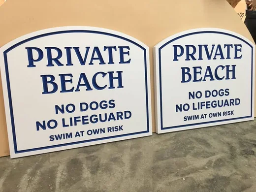 Matching Private Beach regulatory signs with blue lettering, border and arched tops